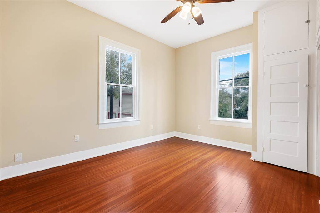 Unit 1: Tranquil second bedroom. Tucked quietly on the main level, this bedroom offers recently refinished hardwood floors, beautiful natural light, and built-in storage—perfect for a cozy guest room.