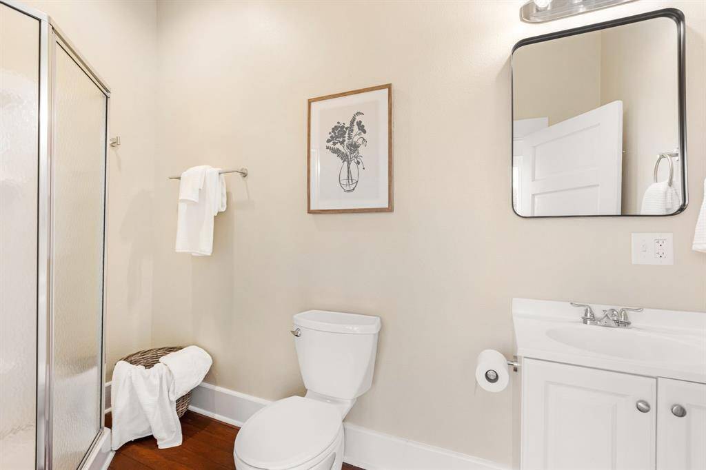 Unit 1: Upstairs refresh. The second full bath offers a sleek stand-up shower, updated lighting, and soft neutral tones that feel straight out of a boutique hotel.