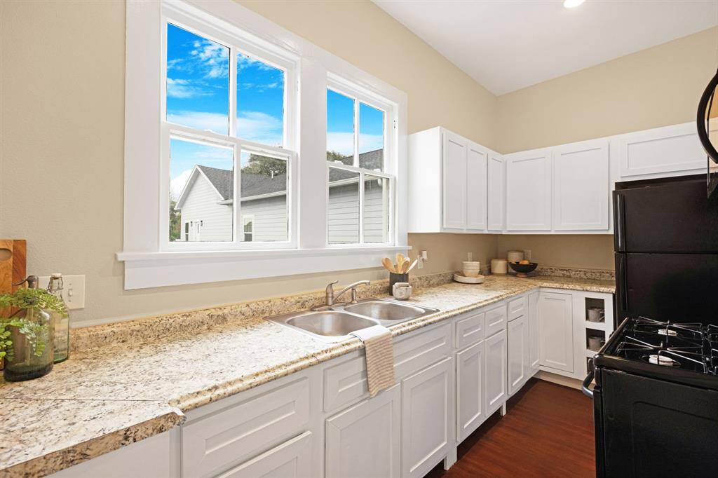 Unit 1: Sunlit culinary space. Bask in the natural light pouring through these large windows as you prep meals in this bright, cheerful kitchen featuring crisp white cabinetry and granite-style formica countertops.