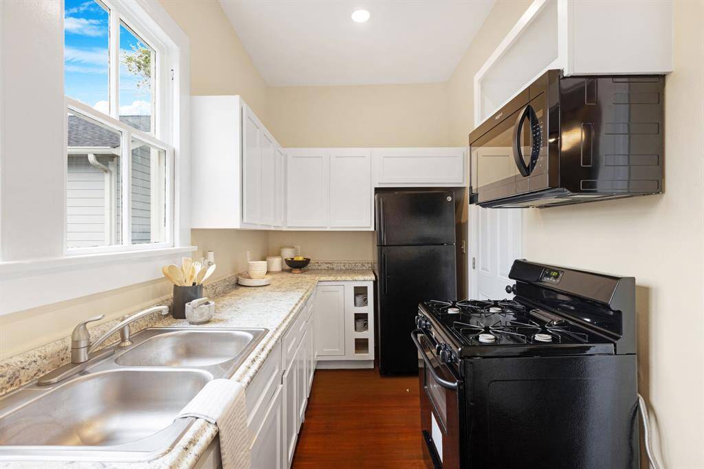 Unit 1: Clean, crisp and functional. The kitchen continues with ample storage, black appliances, and a gas range—all ready for your favorite recipes or takeout nights.