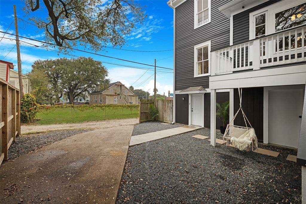 A dreamy little backyard escape with alley access, gravel driveway, and the sweetest porch swing under the trees. It's giving “endless summer.”