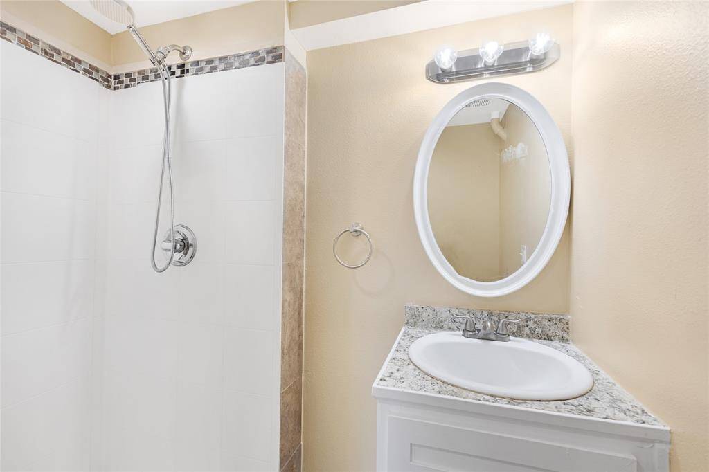 Unit 2: Updated bathroom. Fresh and functional, this bathroom features a beautiful tile shower, modern lighting, and a sleek vanity that ties it all together.