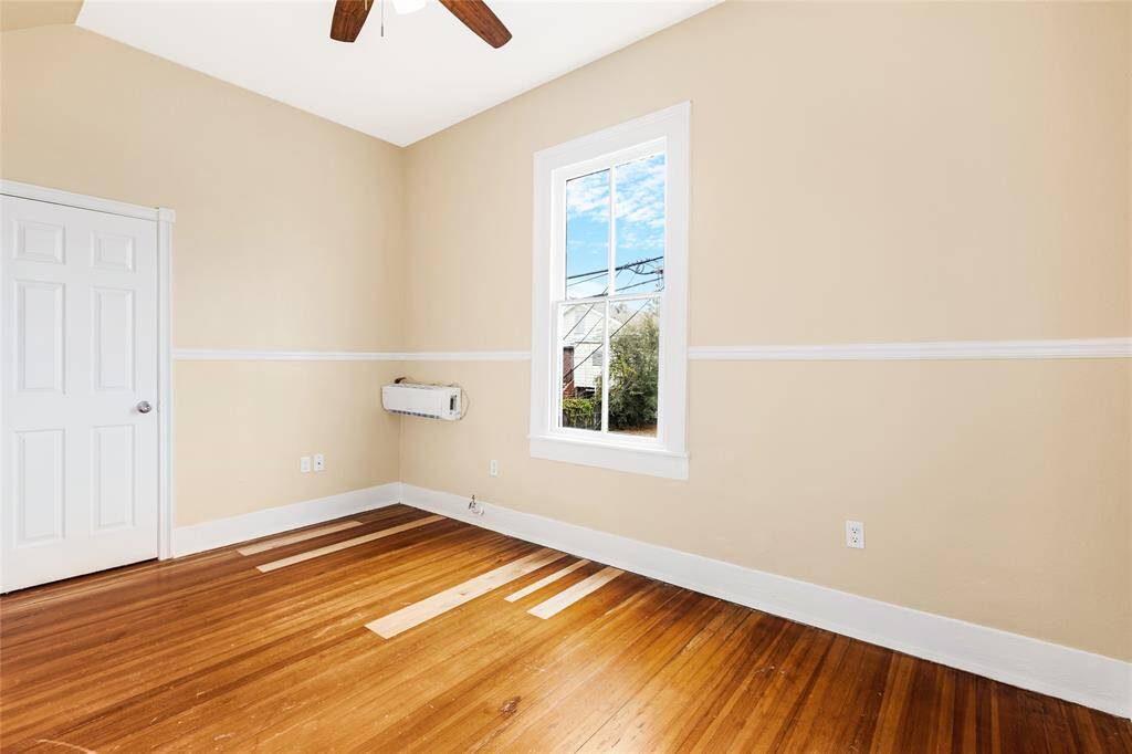 Unit 2: Room to dream. This spacious upstairs bedroom boasts beautiful natural light, a high ceiling with a fan, and plenty of space to create your dream setup.