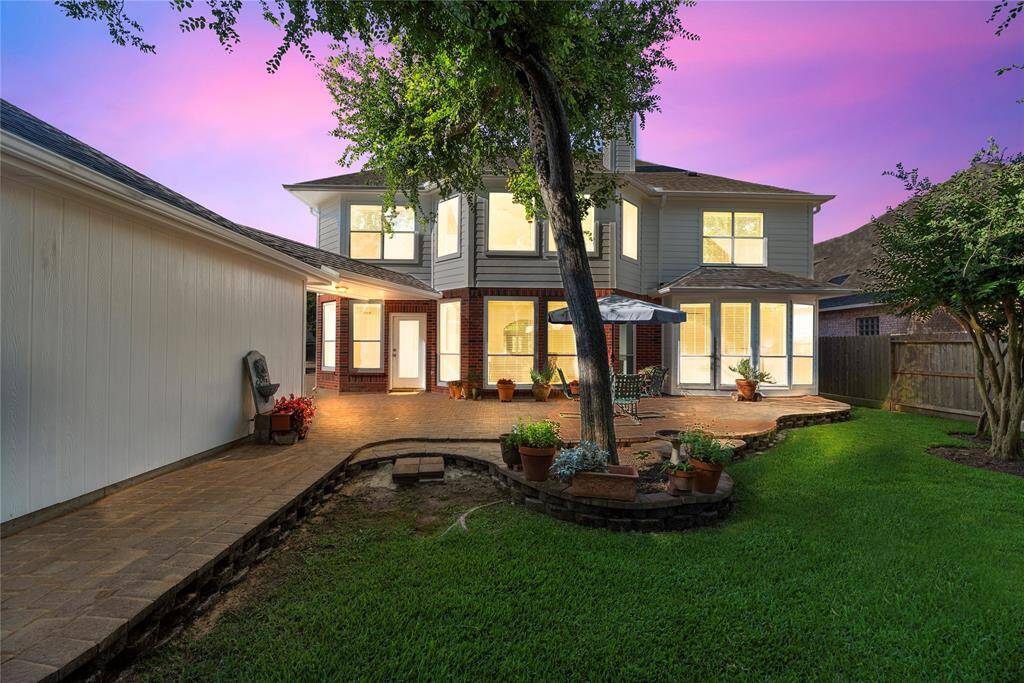 The backyard showcases a beautifully designed custom patio, perfect for outdoor dining, entertaining, or relaxing in style. Surrounded by lush landscaping, it offers a private retreat with plenty of space to unwind or host gatherings.