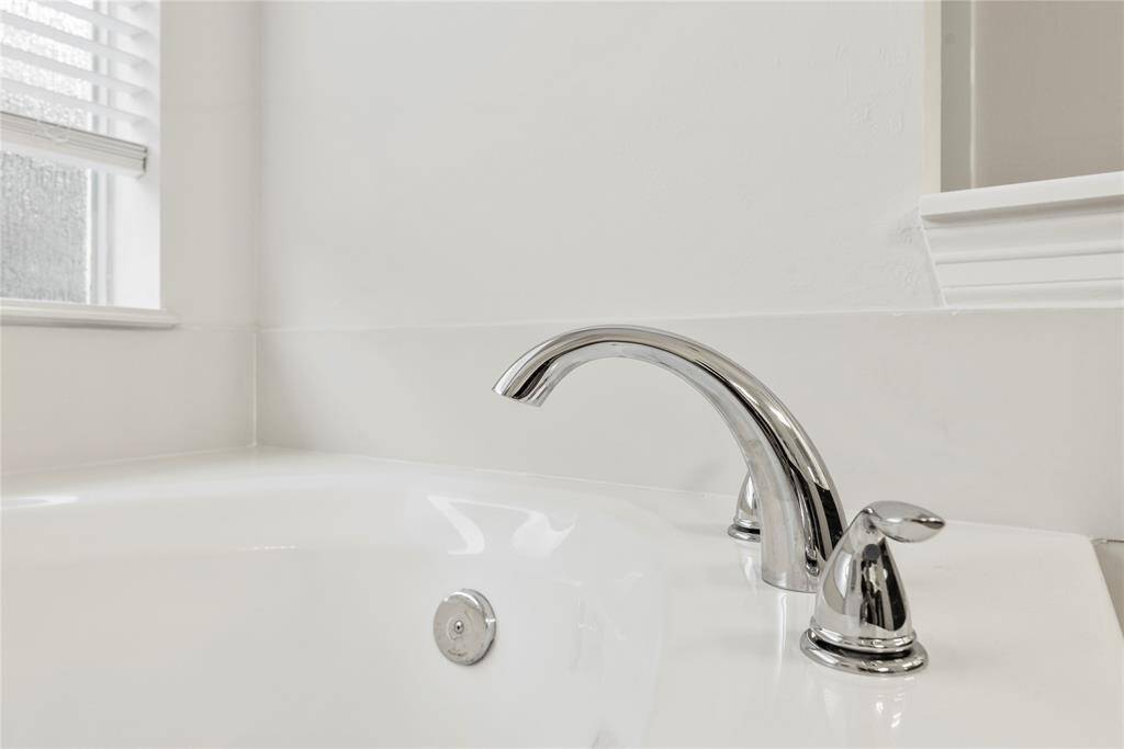 The jetted bathtub features a sleek, modern faucet designed for both style and function.