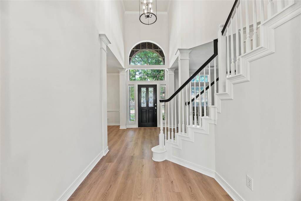 Gracefully and gently curving, the traditional wooden staircase features bright white spindles, an oak railing, and fully carpeted stairs. Visually, it appears elegant, yet inviting.