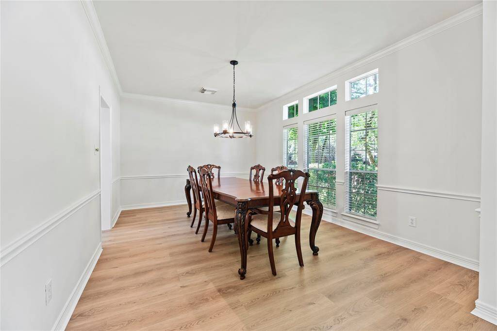 Fanciful dinners or a casual romantic dinner for two are elevated in the formal dining room. Thick white crown molding and the delicate light fixture add just the right amount of opulence for a chic dining experience.