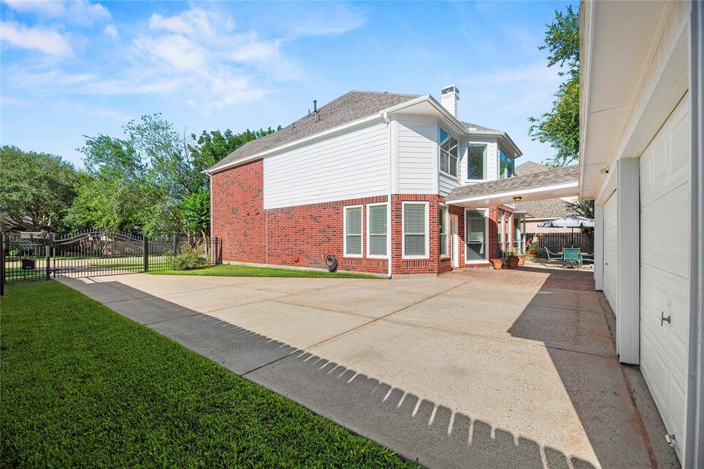 A solar-powered driveway gate provides both convenience and added security. Behind it, a spacious 3-car garage offers ample room for vehicles, storage, or even a workshop setup.