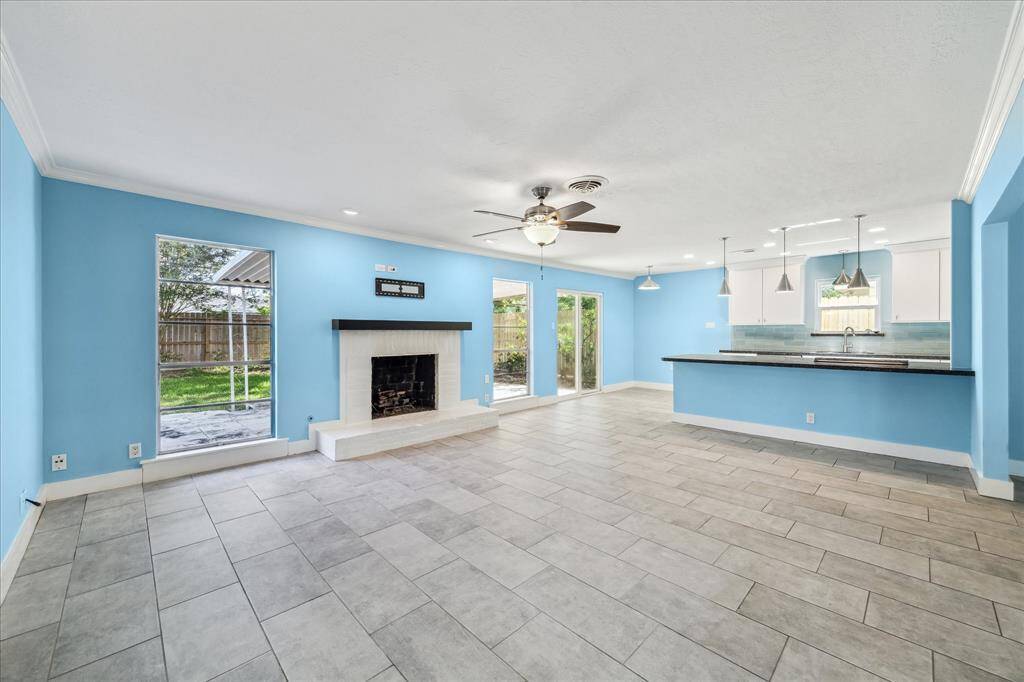 Gorgeous focal-point gas fireplace, framed by floor length windows overlooking the manicured back yard.