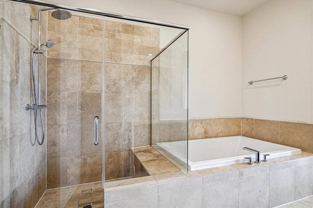 Oversized glass enclosed stand up shower (with a seat) & tub to relax in after a long day at work.