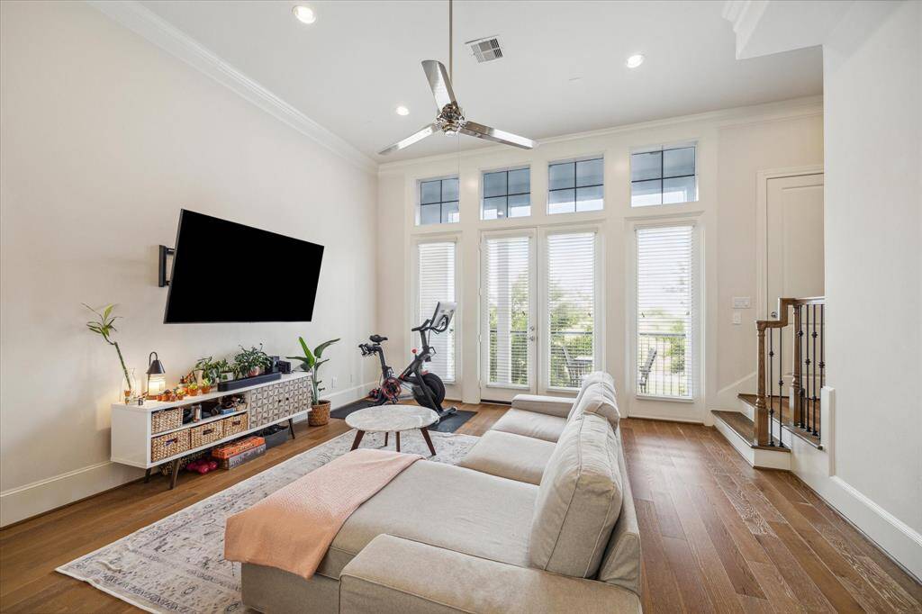 The Living Room has 12 foot soaring ceilings, plenty of windows that flood the room with natural light, recessed lighting, hardwood floors & crown molding highlighting this area.