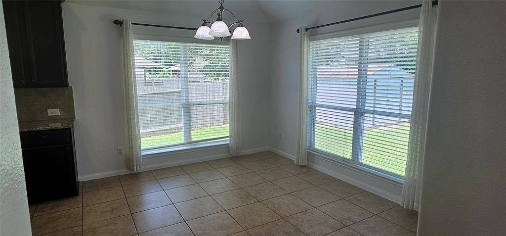 Breakfast room again with lots of natural light open to the kitchen with a door to the covered patio and back yard