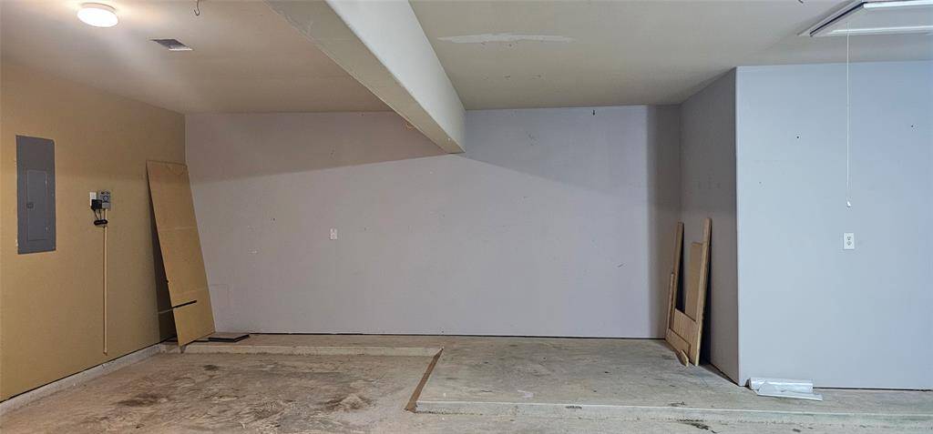 3rd bay of the garage has interior fuse box and sprinkler system panel. Another angle the garage additional space for storage.