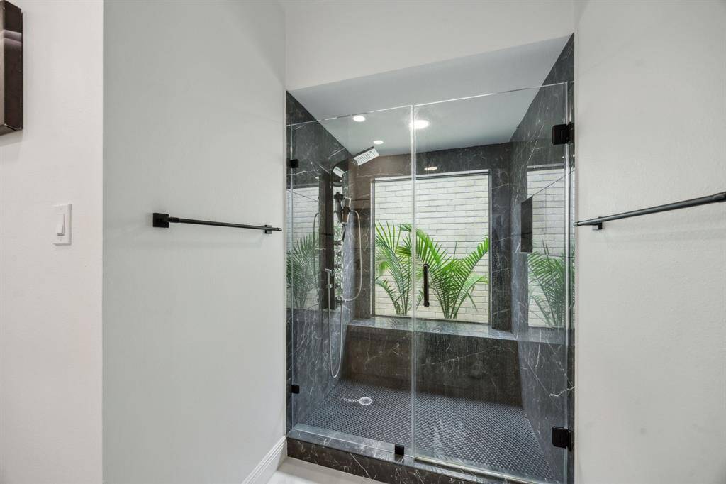 Gorgeous tile and picture window make for a luxurious bathroom setting.