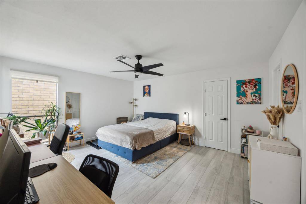One of two secondary bedrooms features access to the bath and corner windows overlooking the outdoor living space.