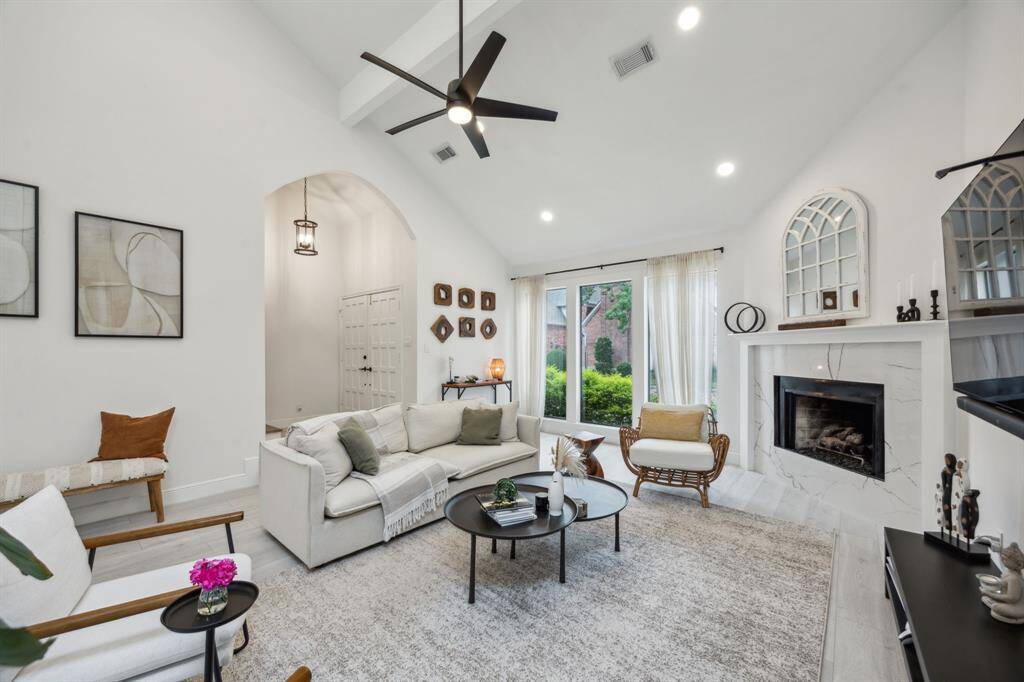 Living room boasts high ceilings, recessed lighting, and wood-like floors throughout.