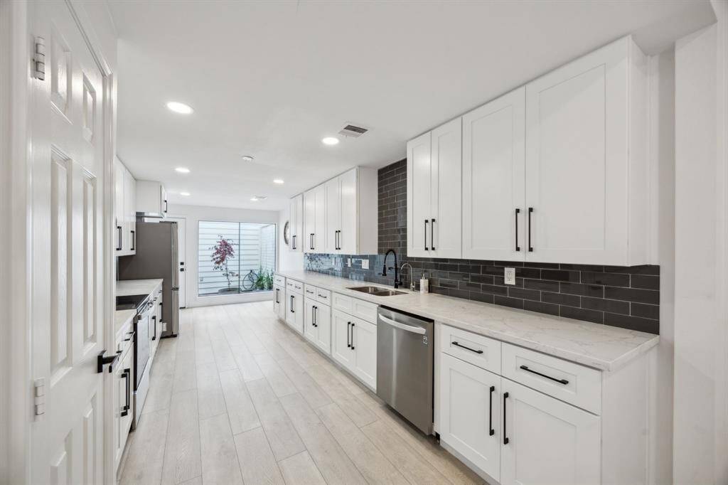 Beautifully updated kitchen features custom cabinetry, pantry, and Quartz countertops.