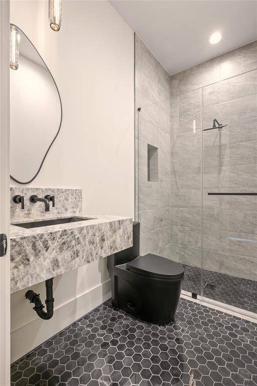 Next to the office / 5th bedroom you will find the downstairs bathroom.  Accentuated with Labradorite quartzite it makes a beautiful statement
