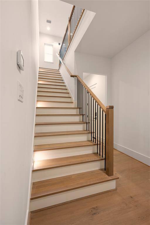 Stairwell leading upstairs to the primary and remaining secondary bedrooms as well as the cathedral ceiling gameroom.