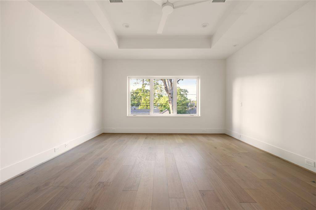 The Primary bedroom overlooks the backyard and is highlighted by a tray ceiling