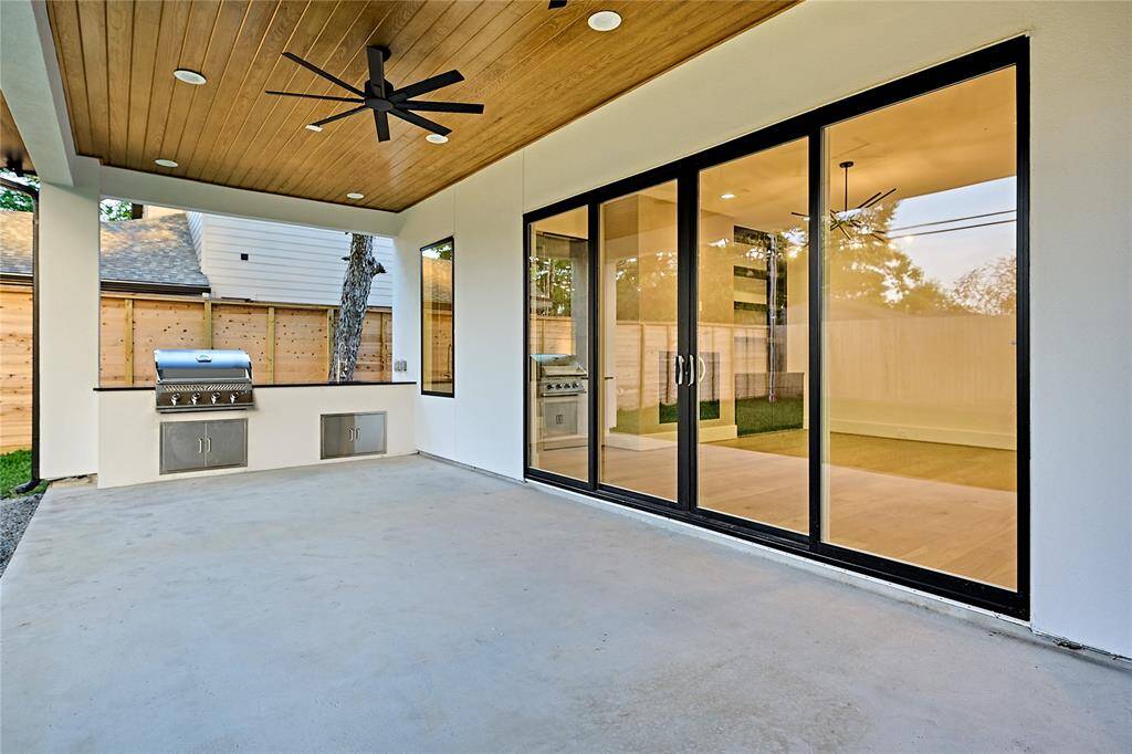 The back porch features a stained ceiling as well as a built-in gas grill and a large counter providing plenty of space for serving freshly grilled food.
