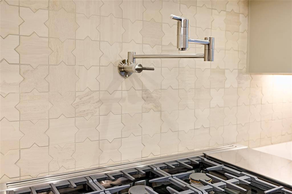 A close up of the limestone mosaic tile and the pot filler to help with meal prep.