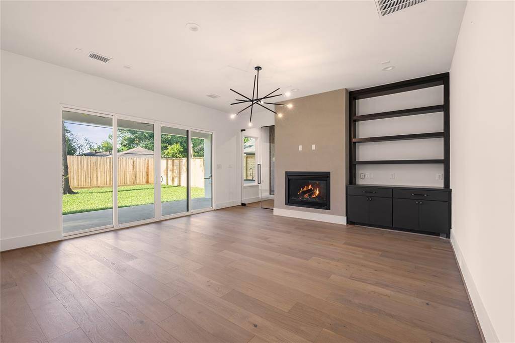 Off the kitchen is the living room that is flanked by a large sliding glass door offering a view to the back yard and the outdoor grill and patio.