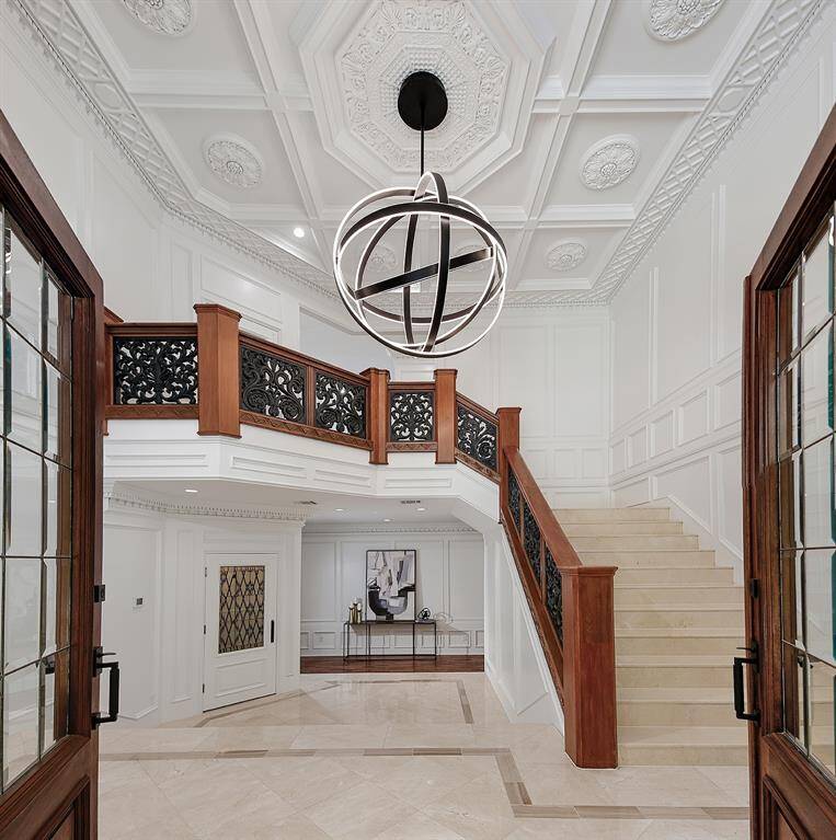 Dramatic Entry with exquisite millwork from ceilings to paneled walls