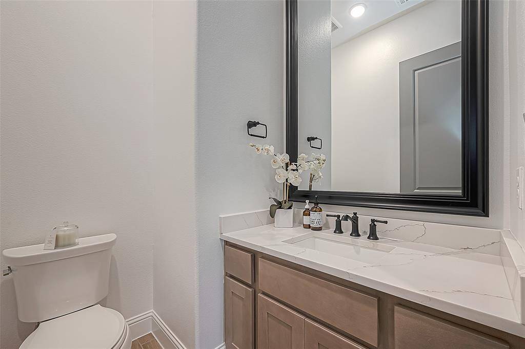 Elegant guest bathroom featuring a sleek vanity with a quartz countertop