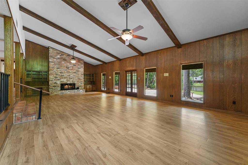 This Large open Living Room offers so much varsatility. Newly installed Luxury Vinyl Plank floors installed around 2017. To the Left is wide open to the Kitchen and Bar.  The wall of windows here overlook Little Lake, and the large trees.