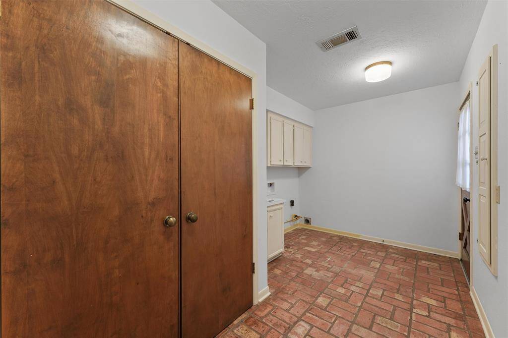 The Utility Room boasts both gas and electric hookups for the Dryer, plus a utility sink and countertop. The door to the right leads out to a side porch across from the detached garage, which makes a convenient entry.