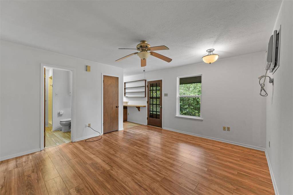 Another view of the Quest Quarter / Garage Apartment, it offers laminate wood plank flooring, it's own AC unit, and direct access to the wooded backyard, and the detached garage.