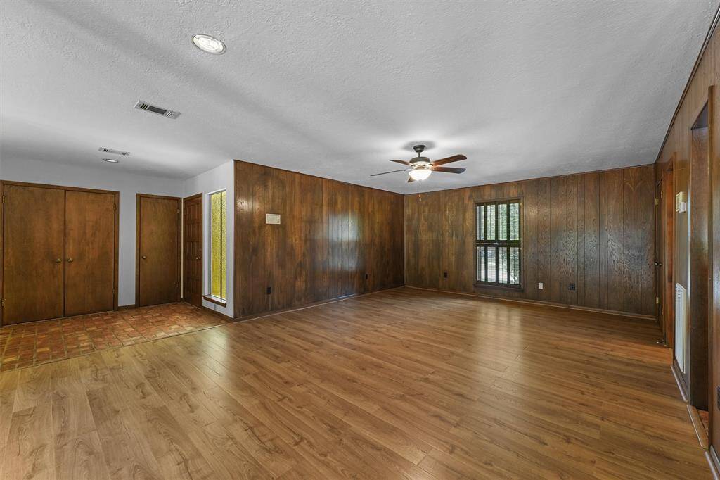 Right off the main entry is this large Flex Room, can be a Formal Dining Room, Office, Gameroom, or closed off to be used as an additional bedroom. That window looks our to the front yard and cul de sac. To the Right is a closet, a Half Bathroom and then an opening into the Wet Bar. On the left of this photo is the front door, and storage closets.