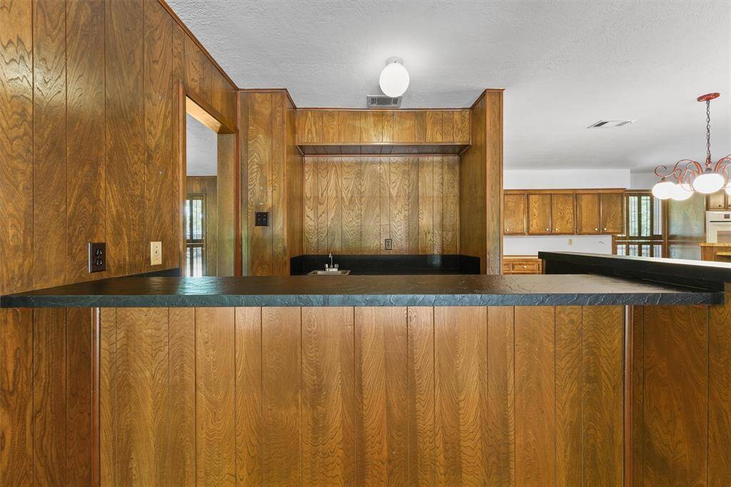 This house is great for entertaining!  A Wet Bar sit between the Flex/Dining/Game Room and the Breakfast Room/Kitchen. Leathered countertops and a bar sink, plus lots lower cabinetry for extra storage.