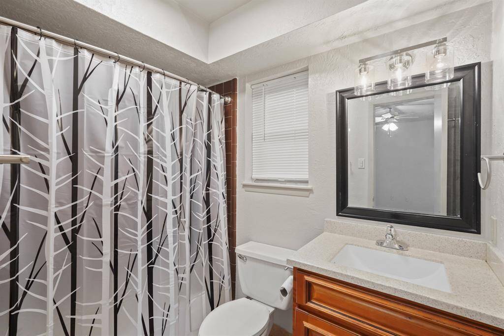This full bathroom is located just across the secondary bedroom and is the perfect place for guests to get ready in while visiting. It features beautiful countertops and cabinets, large mirror, and a tub and shower.