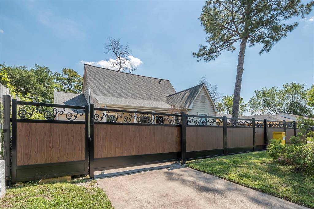 The ornamental wrought iron fence with wood look privacy panels was installed in 2023. It features an automatic driveway gate with remote and a keypad opener. There is also a pedestrian gate and an oversize secure mailbox.