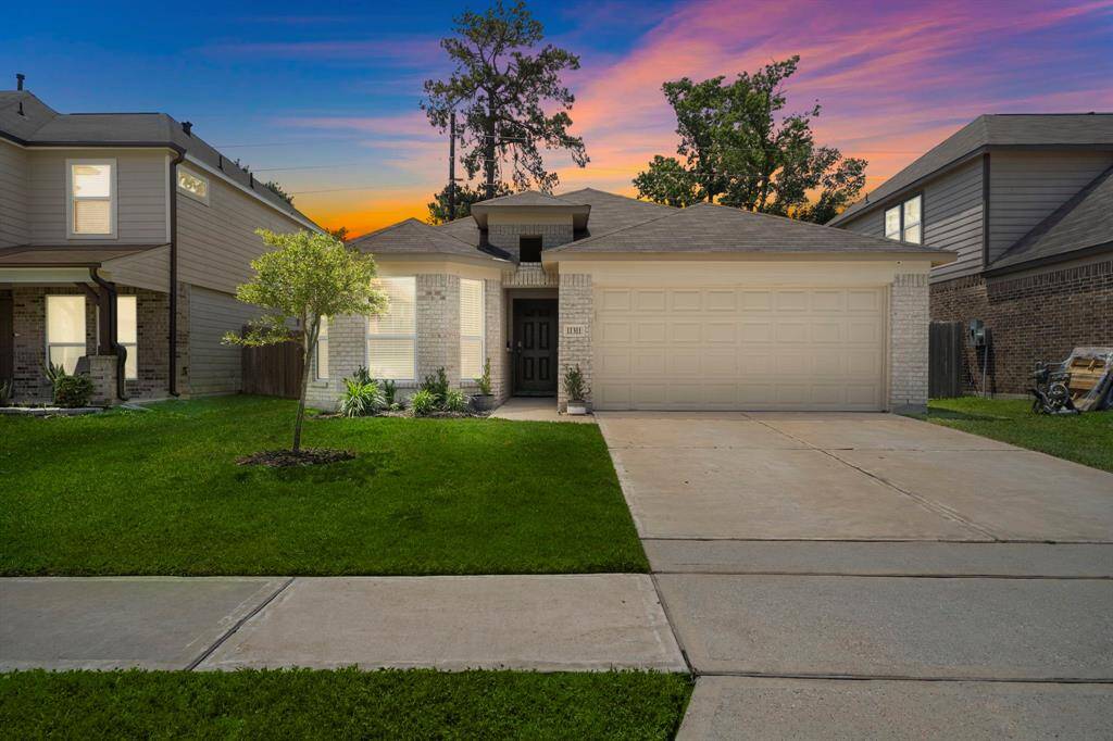 Charming single-story home with a two-car garage. The property features a well-maintained lawn and a welcoming front entrance, offering great curb appeal.