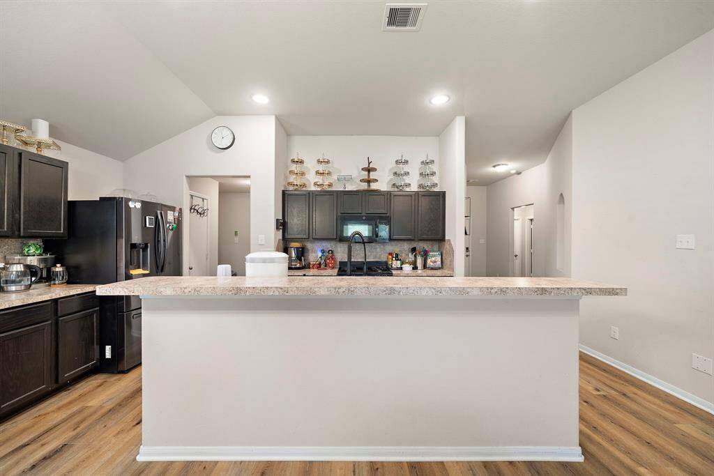 This kitchen features modern dark cabinetry, a spacious countertop.