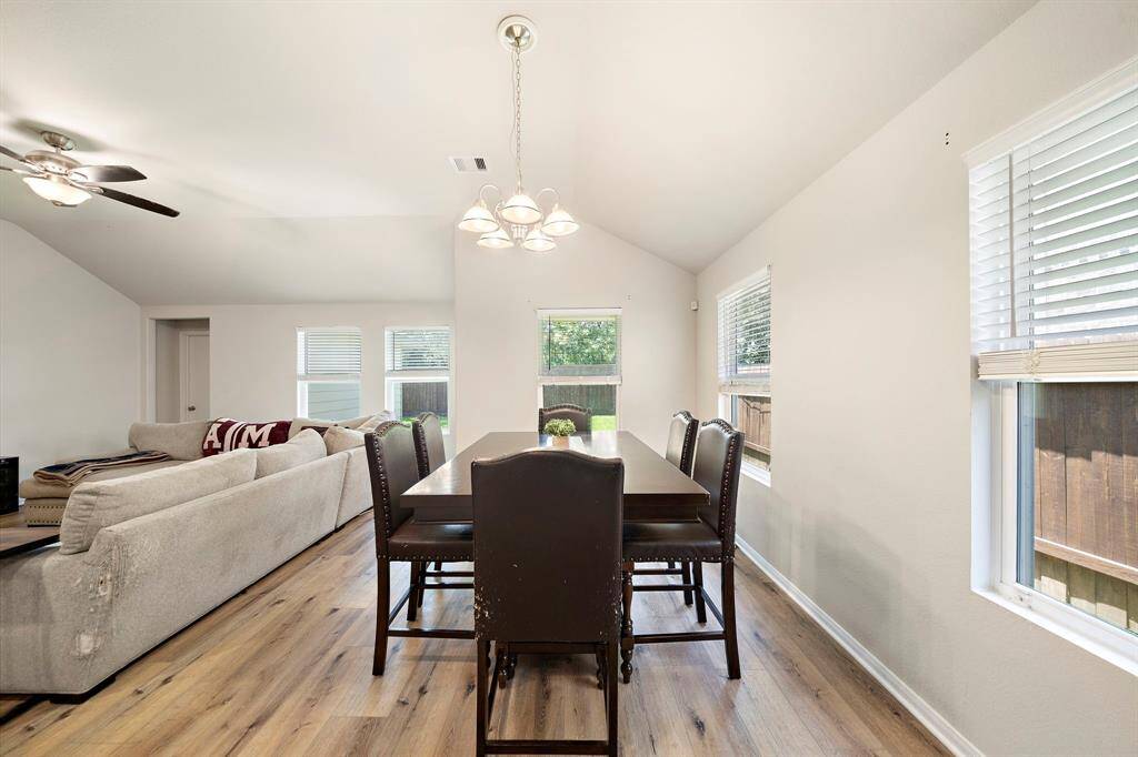 This bright, open-concept living and dining area features large windows, modern light fixtures, and premium flooring, creating a welcoming and spacious environment perfect for family gatherings.