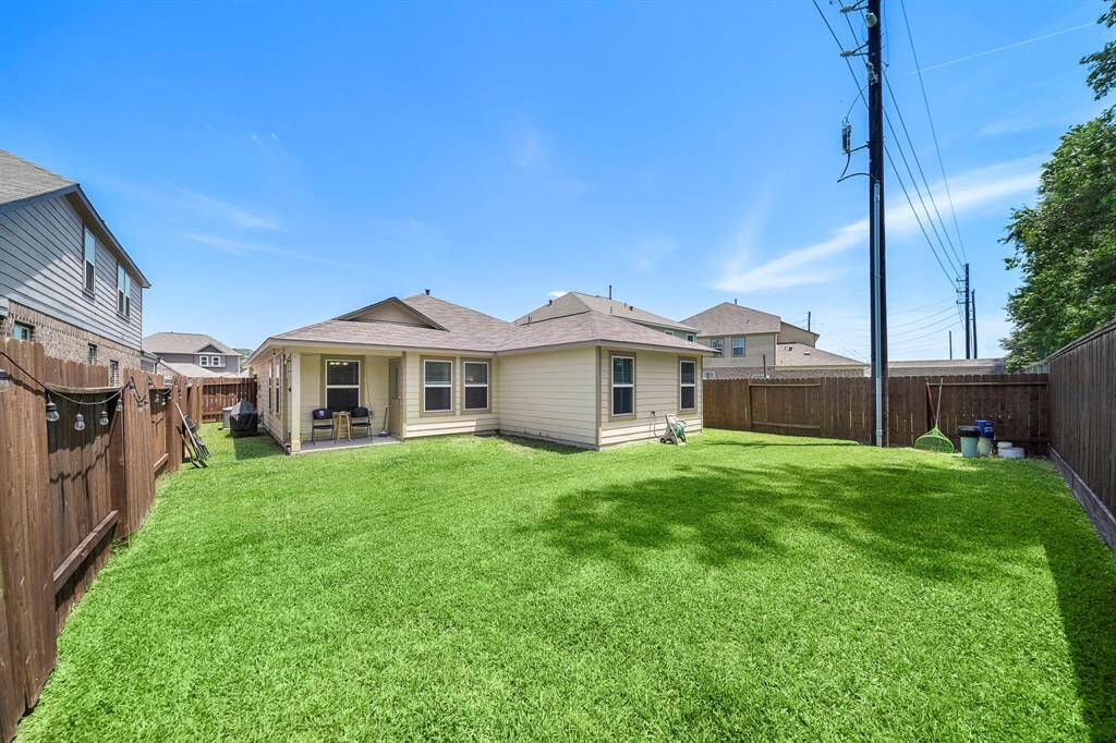 No Back Neighbor. Charming backyard with well-maintained lawn, privacy fencing, and a cozy covered patio perfect for relaxation or entertaining.