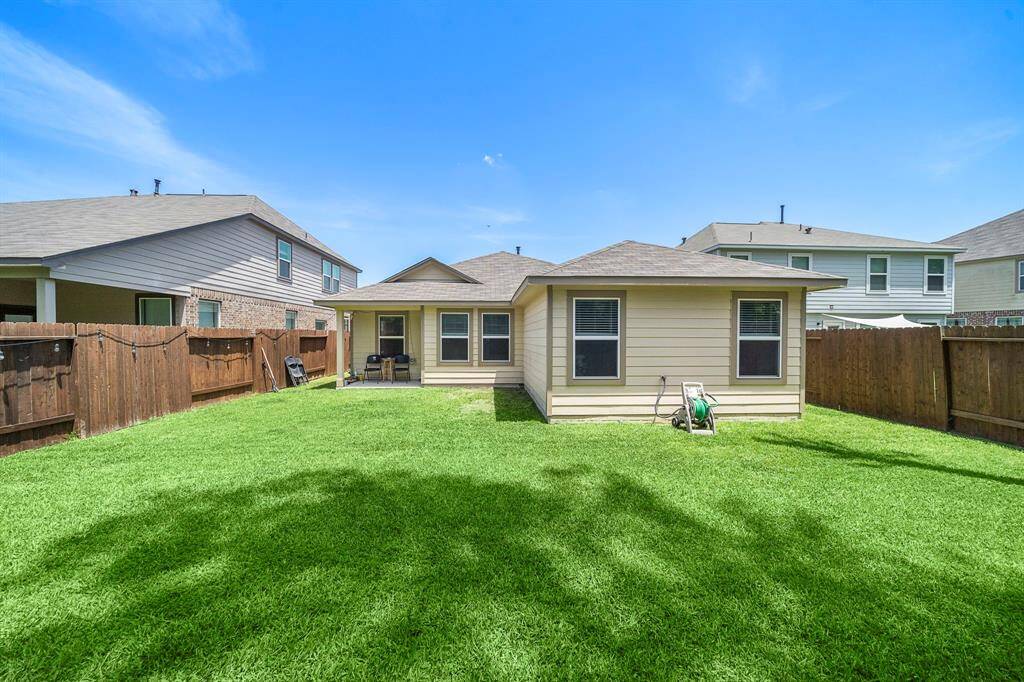 No Back Neighbor. A cozy single-story home with a spacious, well-maintained backyard. Features include a patio area, wooden fencing for privacy, and ample lawn space ideal for outdoor activities.