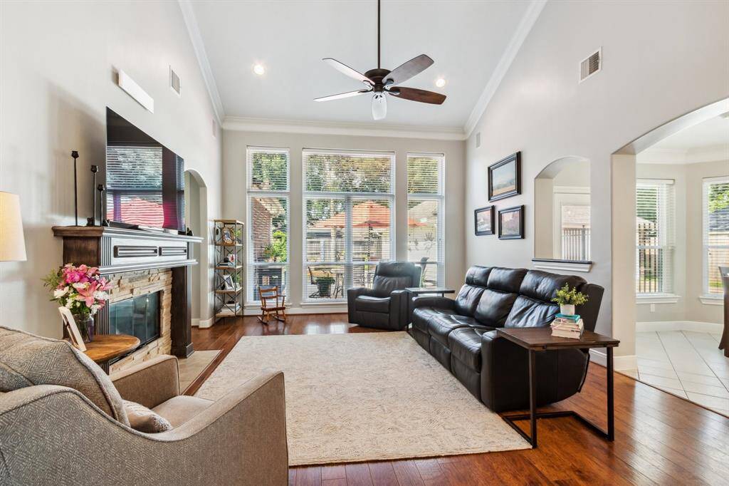 Spacious family room featuring floor length windows overlooking backyard.