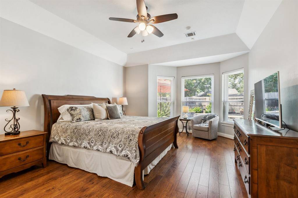 Spacious primary bedroom features sitting area overlooking the gorgeous backyard.