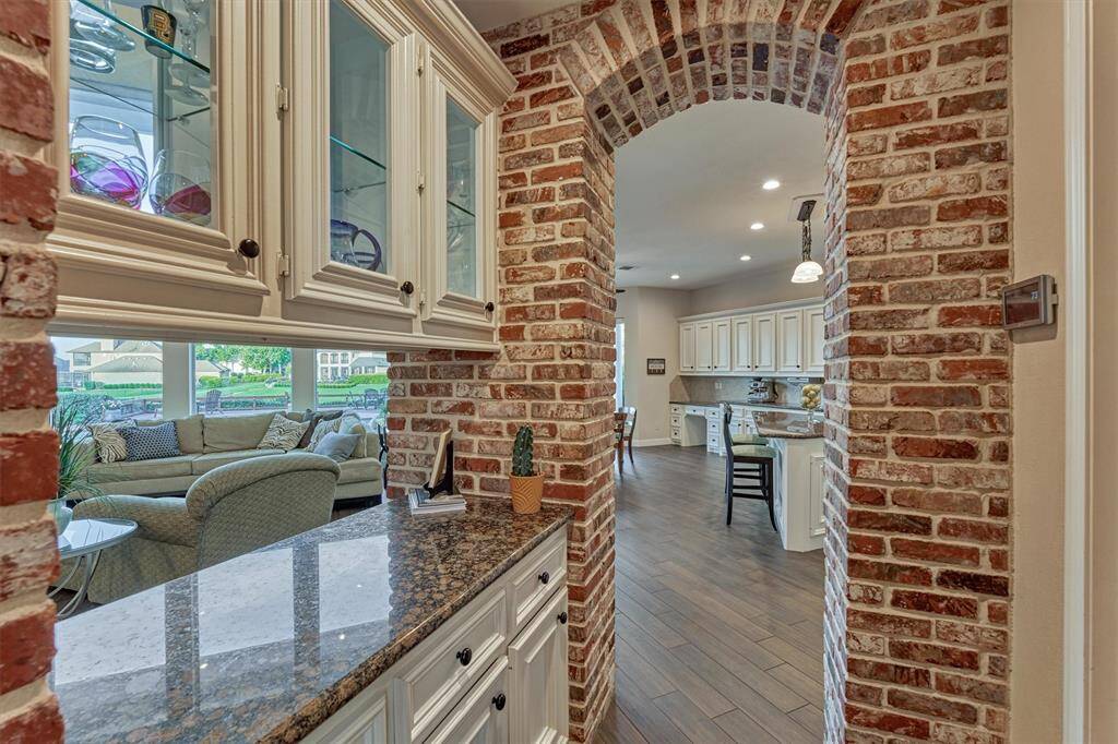 This charming dry bar, highlighted by elegant brick archways, is perfectly situated between the formal dining room and kitchen, with convenient access to the living room. Ideal for entertaining, it offers a stylish spot to serve beverages or set up a buffet for guests.