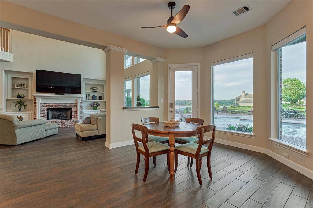 Another view of the breakfast area showcases the stunning scenery, offering a picturesque look at the pool, backyard, and lake beyond.