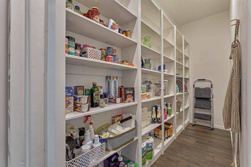 The pantry is a room in of itself with multiple shelves for food, small appliances and paper goods.
