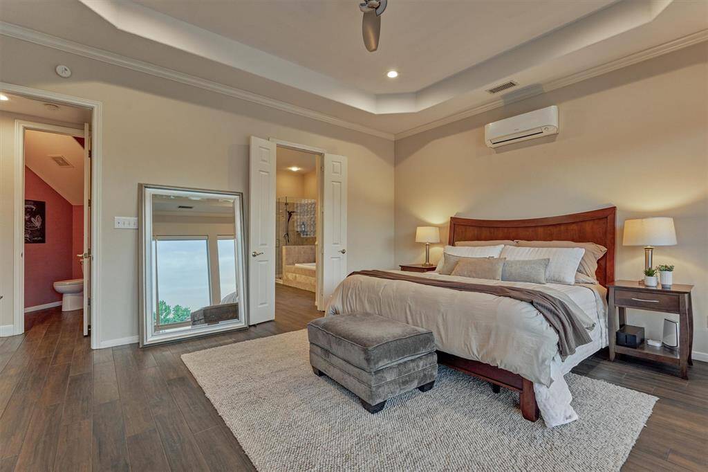 This view of the primary bedroom shows the double doors leading to the ensuite bath.