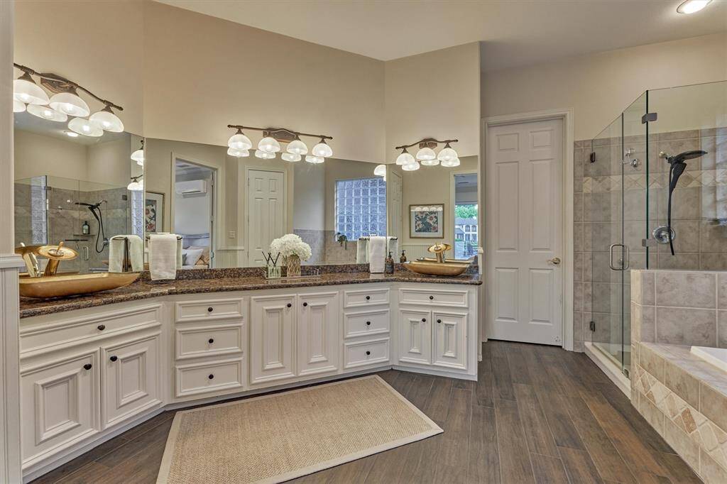 The primary bath offers multiple storage areas with cabinets and drawers. Double sinks with plenty of counter space provide a comfortable space for two.