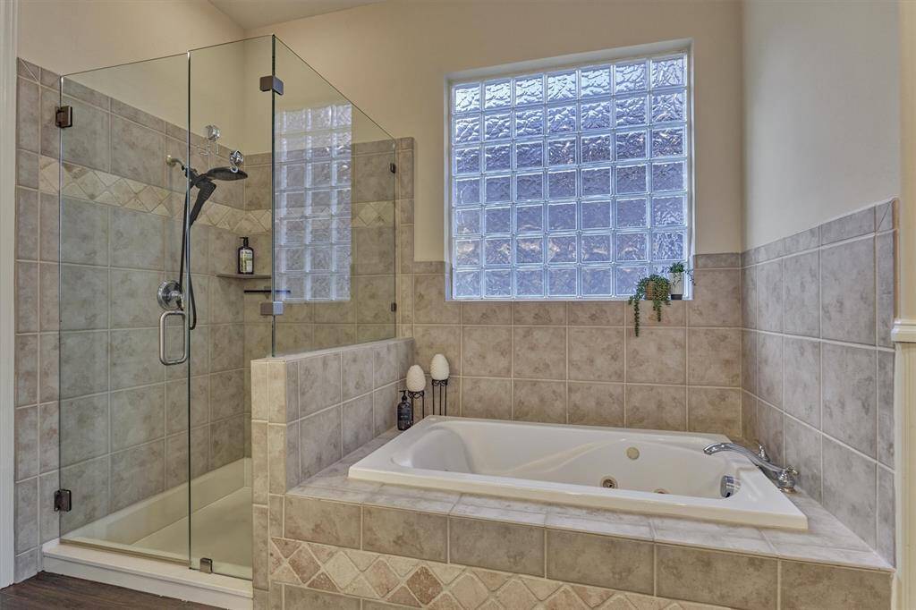 The spa-like bath includes a separate jetted tub and a shower with a seamless glass enclosure—an ideal retreat to relax and unwind after a long day.