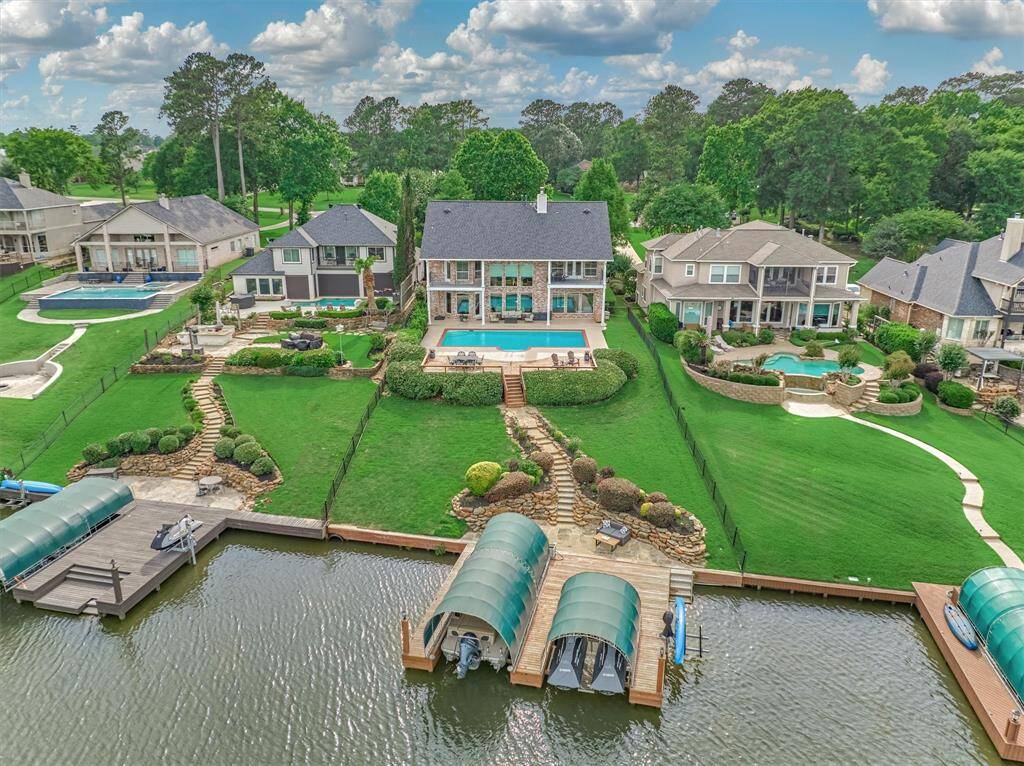 The backyard of this home is a true waterfront retreat, featuring a spacious pool, boat slip with lift, two jet ski slips with lifts, and an additional lift for a third jet ski. Thoughtfully designed landscaping enhances the rear elevation, offering stunning curb appeal from every angle.